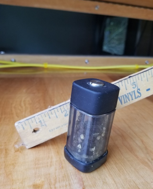 miniature pepper grinder, an inch wide by 4 inches tall