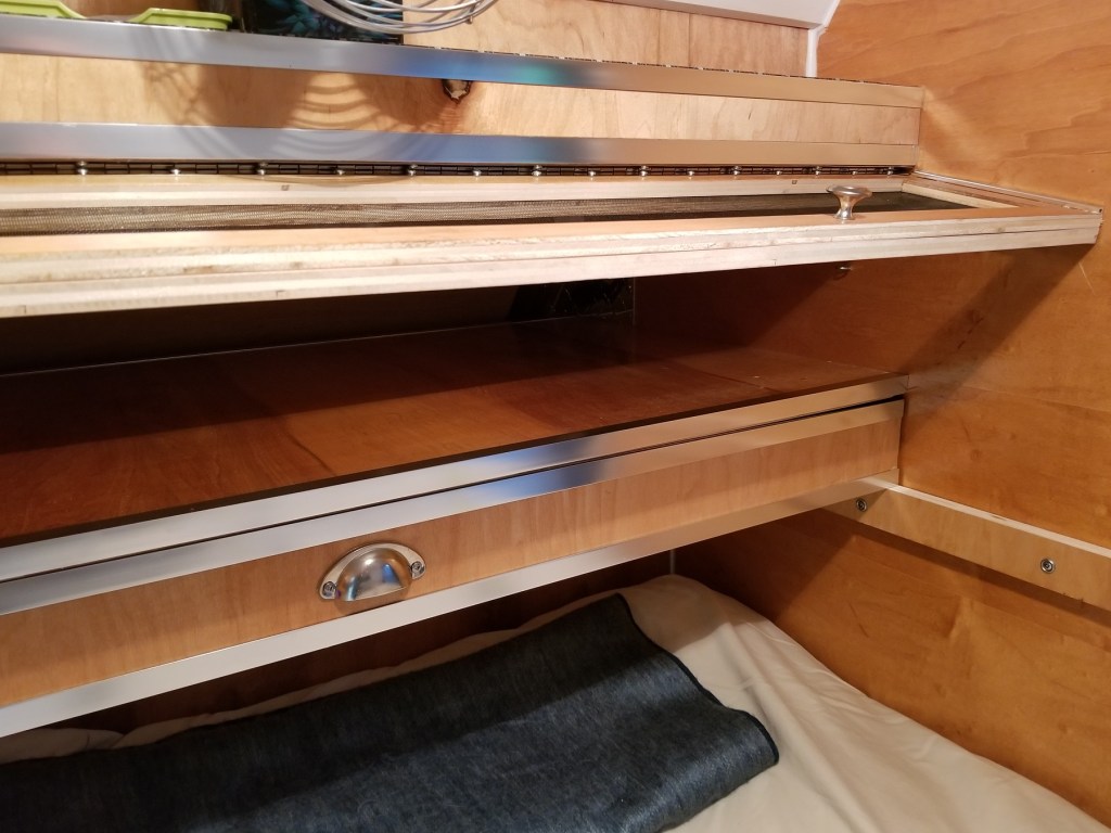 an opened pass-thru from Teardrop trailer galley into bedroom