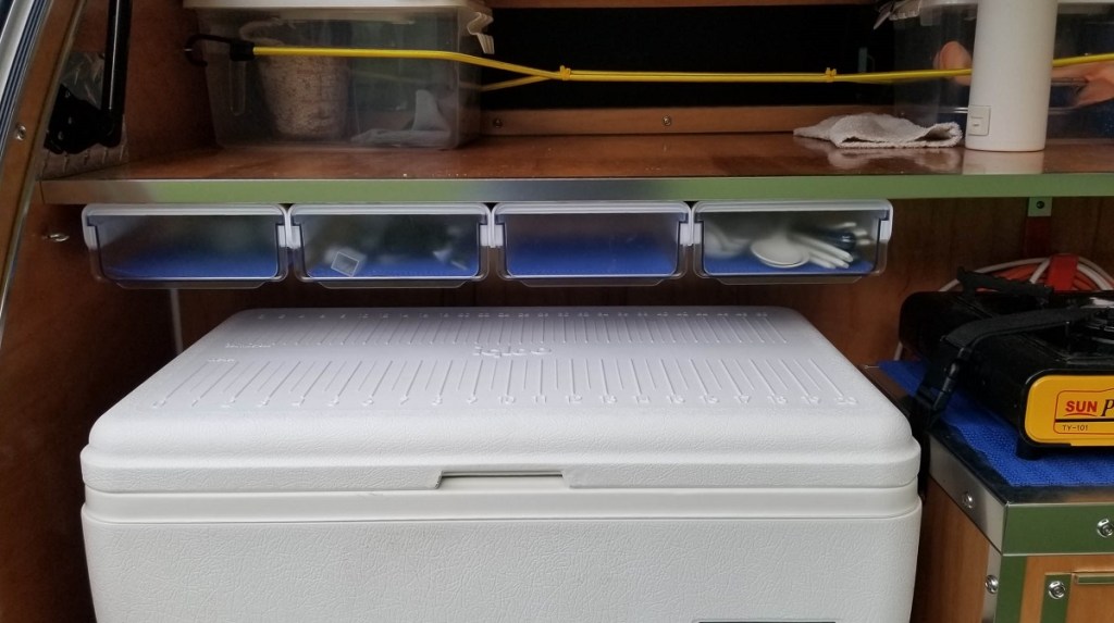 small drawers on underside of counter in teardrop trailer galley
