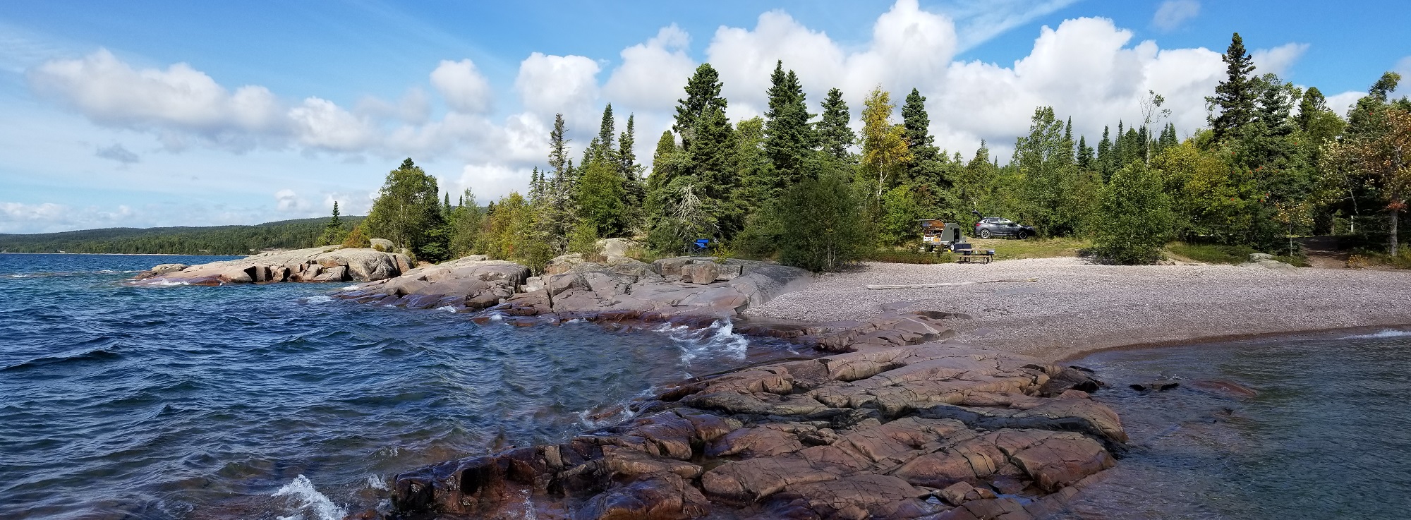 rocky shore of Lake Superior, view back toward a Teardrop trailer