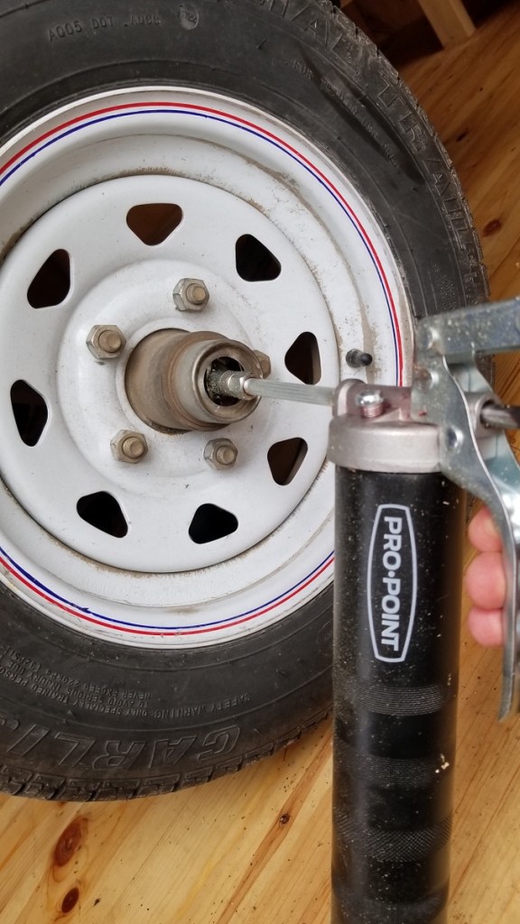 grease pistol attached to wheel hub