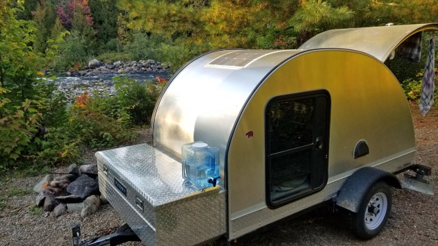 teardrop trailer beside flowing river