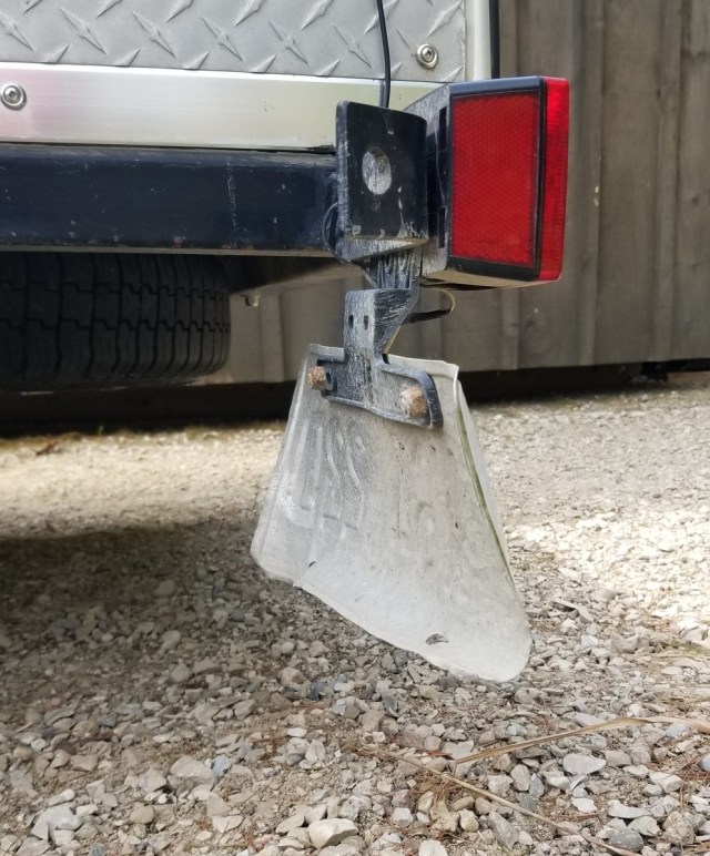 license plate on teardrop trailer fender, showing gravel damage