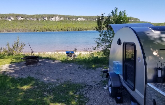 teardrop trailer parked at waterfront campsite