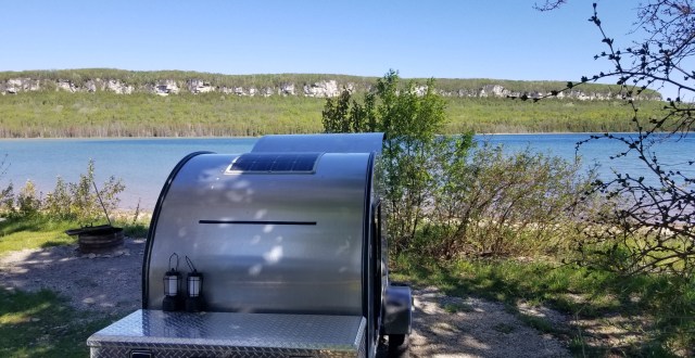 teardrop camper with escarpment bluffs in background